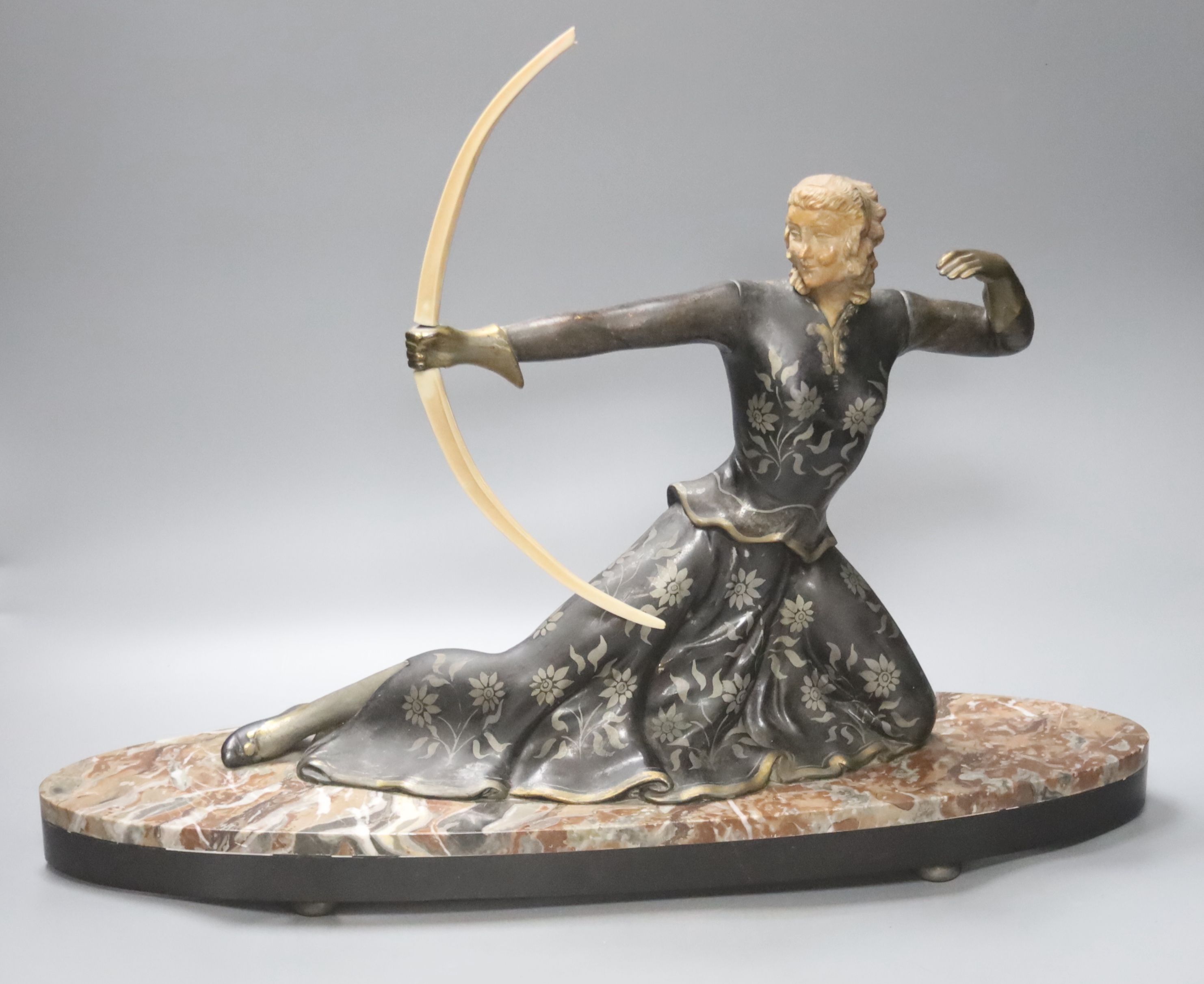 An Art Deco style spelter and marble figure of a female archer, base length 55cm